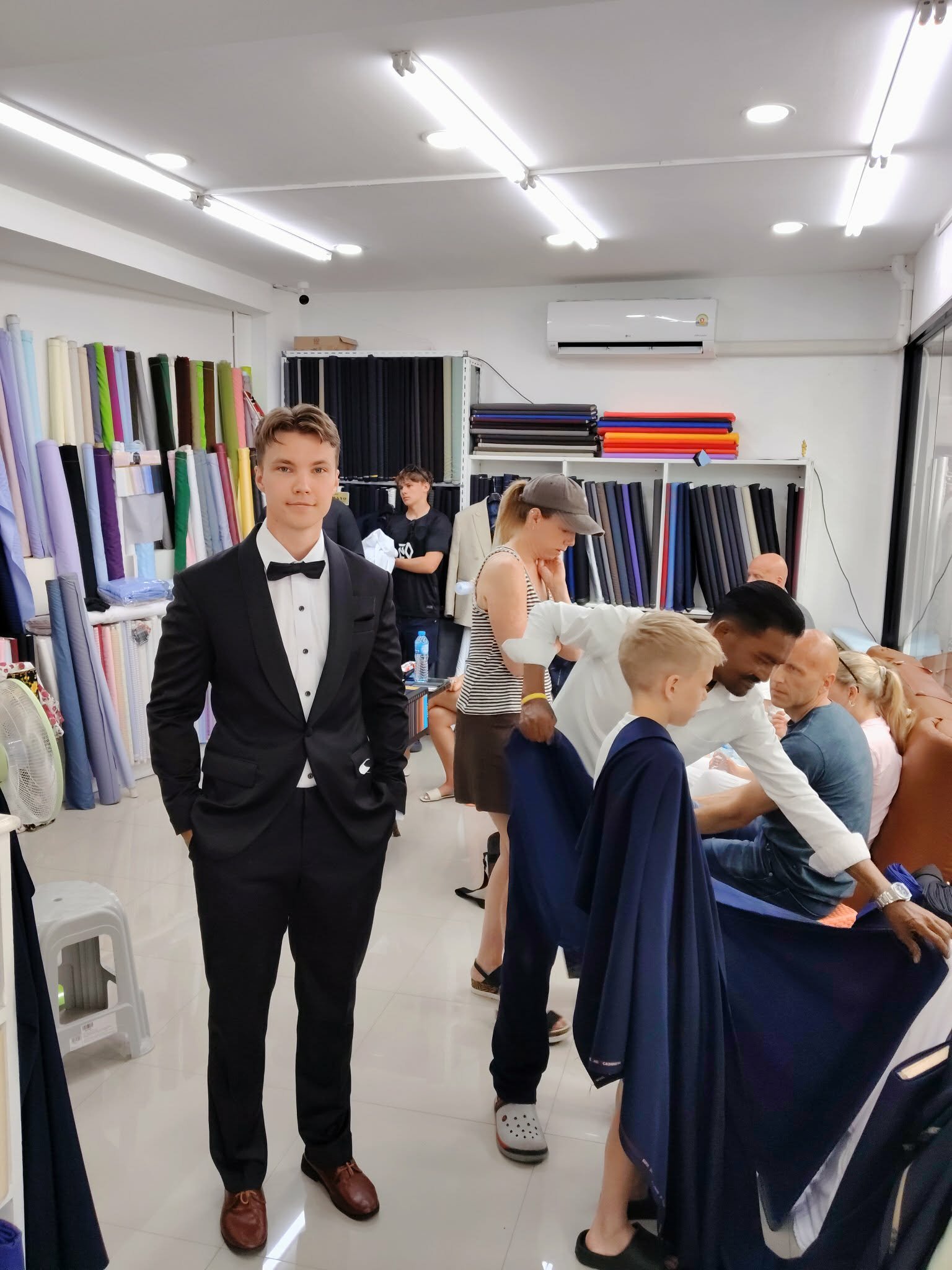 Professional tailor at Zegna Tailor Hua Hin fitting a custom charcoal bespoke suit for a client – precision tailoring in Thailand