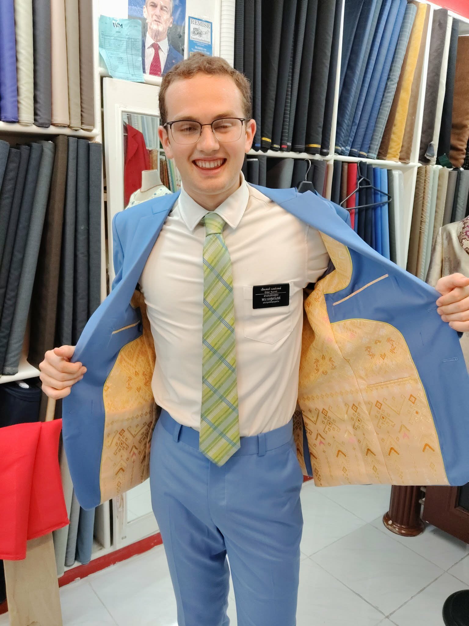 Finished bespoke suits displayed at Zegna Tailor Hua Hin showroom – navy, charcoal, and beige linen custom suits ready for collection